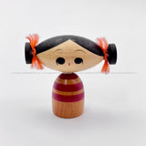 Petite handmade vintage kokeshi doll depicting an adorable girl with an oblong head and pigtails tied with cute pink ribbons. Rare!