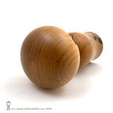 A top view photo of an original, one-of-a-kind modern kokeshi doll by Isao Sasaki. Handmade from beautifully grained hardwood. A pretty kokeshi with a calm expression.