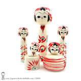 family of five extremely cute kokeshi dolls in the traditional style. A daddy, a mommy, two toddlers and one baby. The baby is in a mini bathtub. The momma is a functional kokeshi; her round body is a hollow bowl and her head and shoulder are a lid. So she can be used for display and to story small items like rings or earrings. All of the kokeshi have large eyes and are very cute. The torsos have a floral design in red and green. What a lovely group of five Japanese kokeshi dolls!