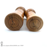A photo showing the signature of kokeshi artist Isao Sasaki. The photo appears on the base of a one-of-a-kind modern kokeshi doll. The doll has a peaceful expression and is made from nicely grained hardwood.