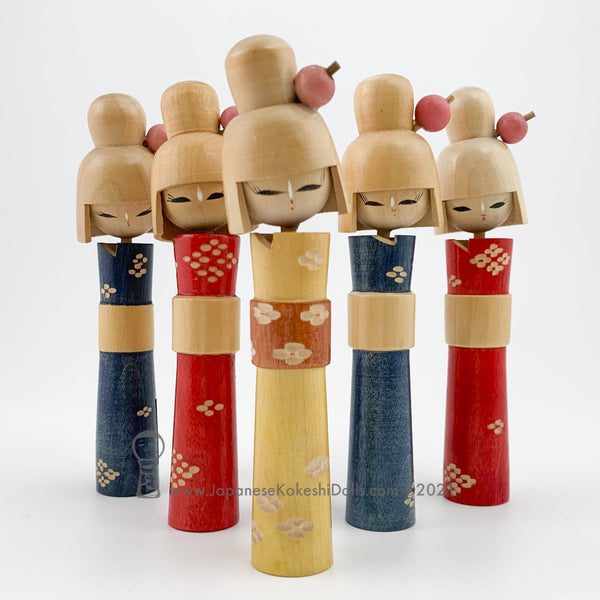 Group of five colorful and rare vintage kokeshi dolls. Slim with hand-carved floral kimonos, beautiful faces with long-lashed eyes, tall hair with kappa-style bands, and lovely kanzashi hairpins